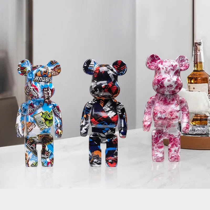 Six blocky bear sculptures in assorted colors arranged on a shelf with warm lighting