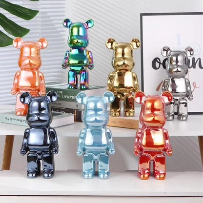 Five blocky bear sculptures in red, gold, and chrome finishes displayed together