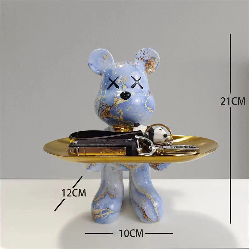 White bear sculpture with pastel pink and blue marble finish on a gold display tray