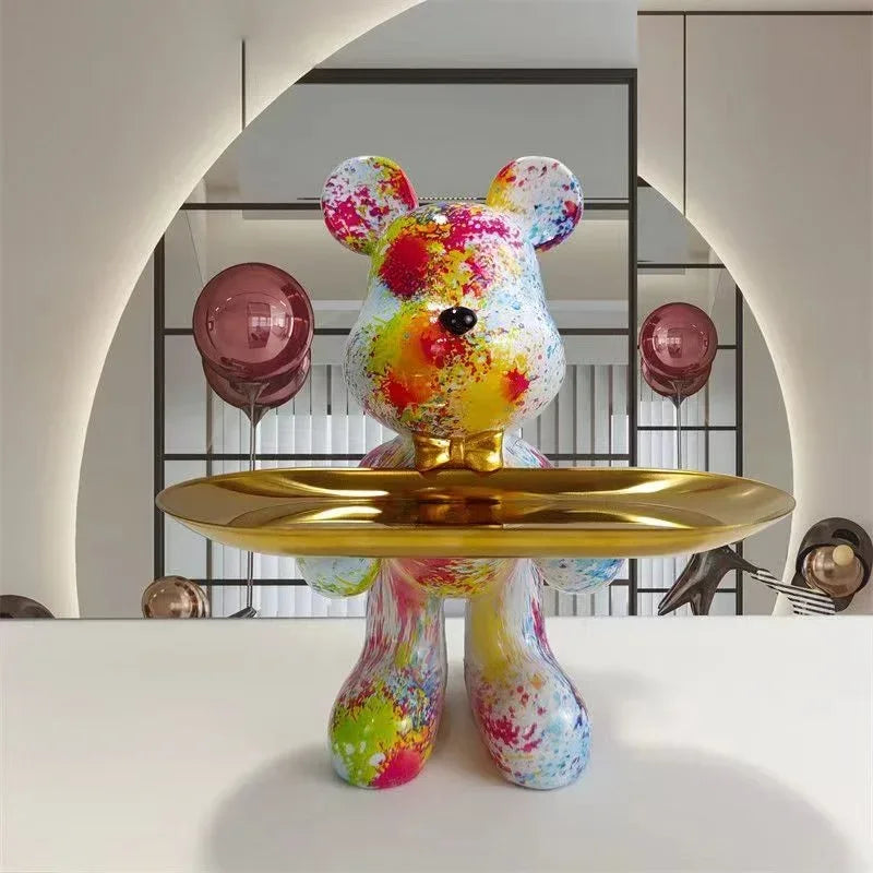 Rainbow graffiti-pattern bear sculpture on a gold pedestal tray, mirrored backdrop