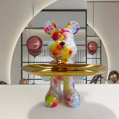 Rainbow graffiti-pattern bear sculpture on a gold pedestal tray, mirrored backdrop