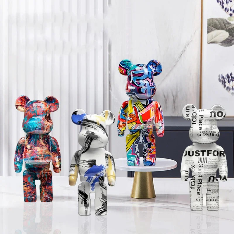 Five blocky bear sculptures in gold, checkerboard, gray, chrome, and black finishes