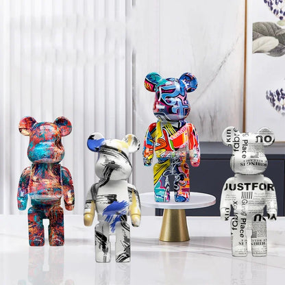 Five blocky bear sculptures in gold, checkerboard, gray, chrome, and black finishes