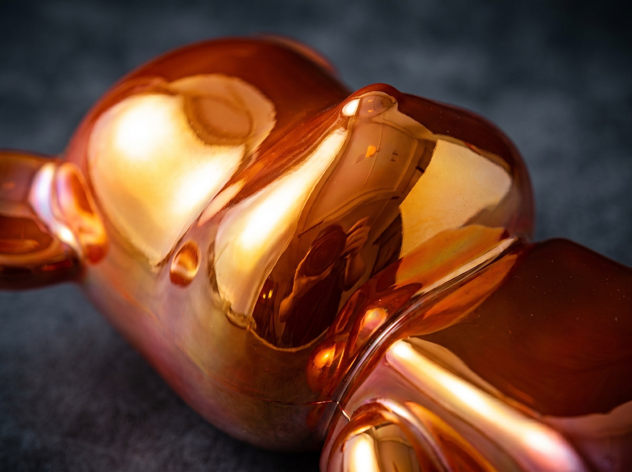 Macro close-up of a glossy resin sculpture surface catching warm light
